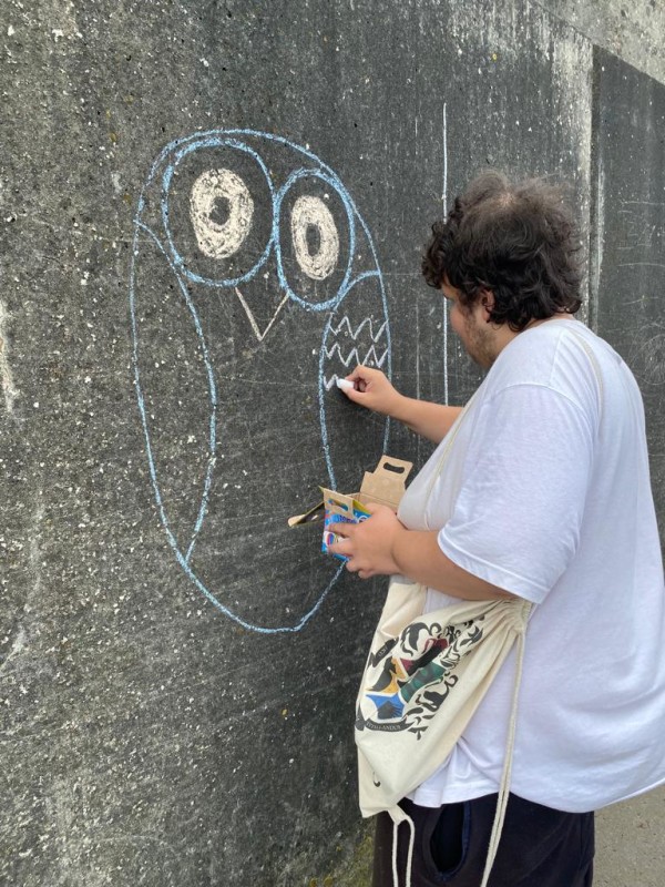 Jason chalking an owl on the wall